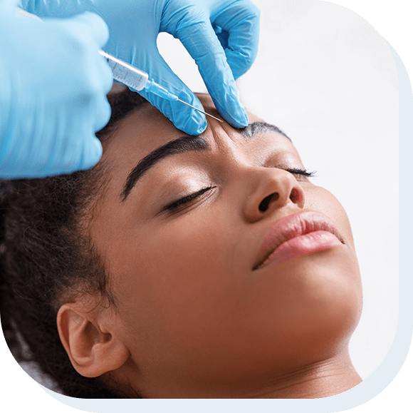 Young african woman receiving botox injection in interbrow zone